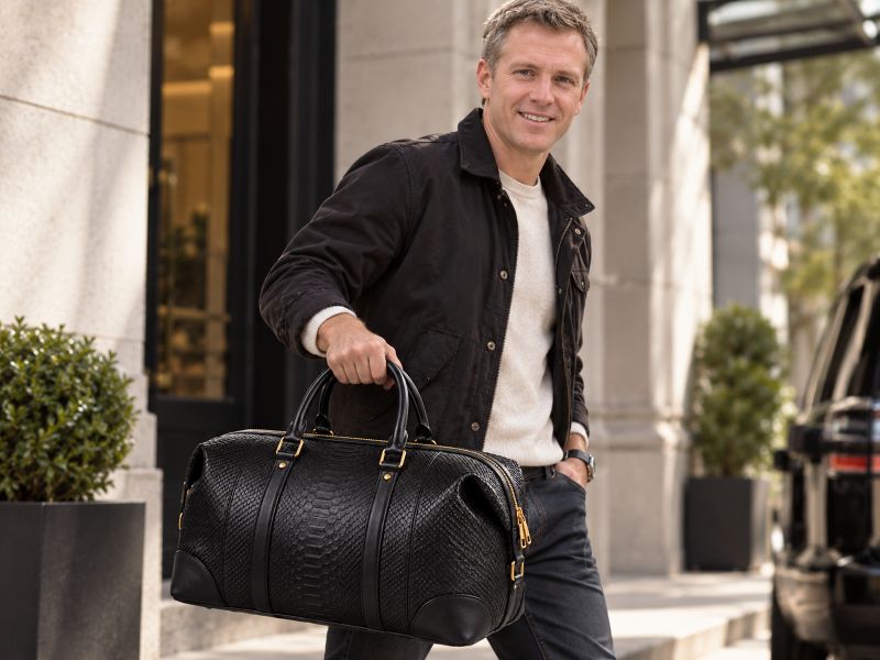 black-snake-texture-leather-duffel-bag-held-by-man