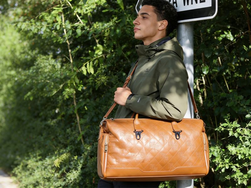 man-carrying-brown-soft-sided-luggage-for-travel