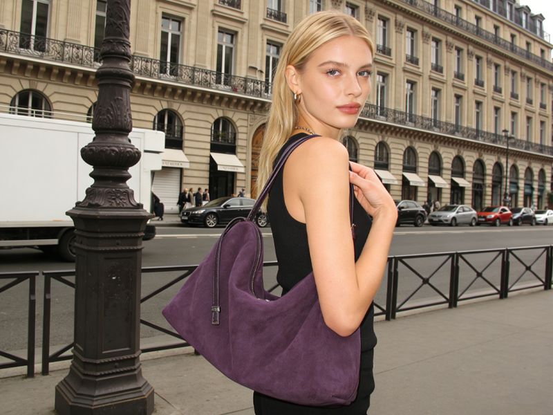 stylish-woman-carrying-purple-suede-hobo-bag-in-parisian-street